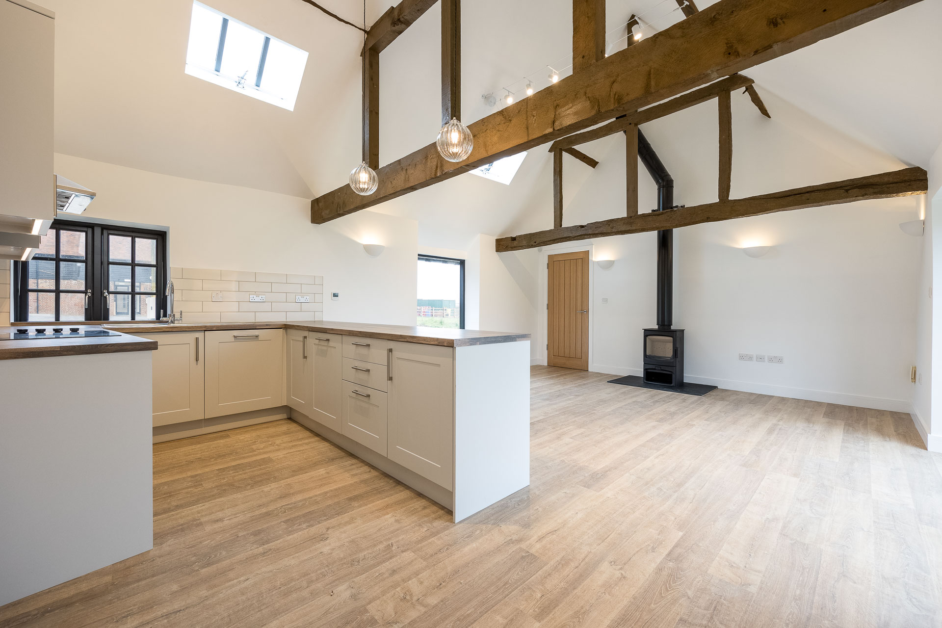 An internal view of a cosy rustic kitchen with wooden beams and flooring at Hard to Find Farm