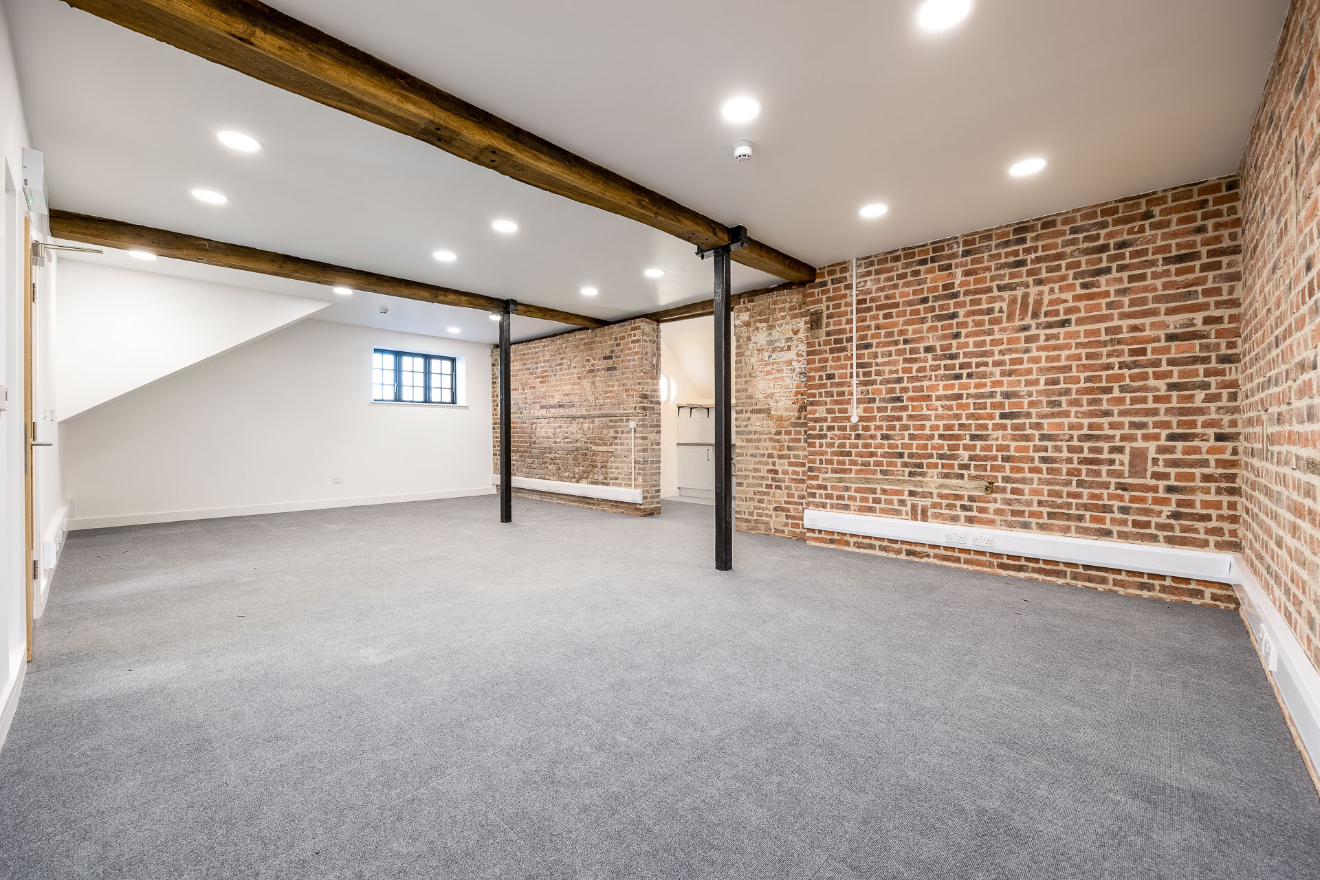 An empty room with brick walls and a ceiling, creating a rustic and minimalistic ambiance at Hard to Find Farm.